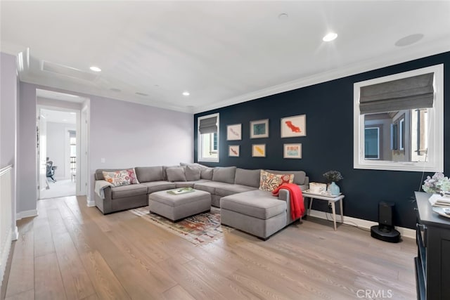 living room featuring light wood-style floors, baseboards, recessed lighting, and ornamental molding