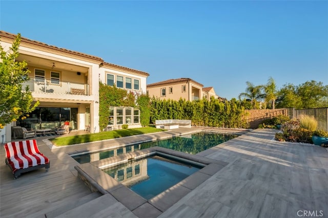 view of swimming pool featuring an in-ground hot tub, fence, and a patio