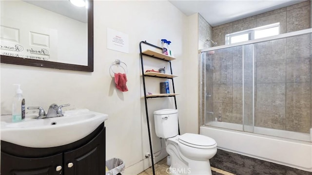 bathroom with toilet, enclosed tub / shower combo, and vanity