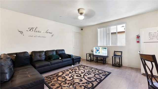 living area featuring ceiling fan, wood finished floors, and baseboards