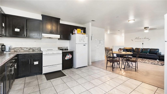 kitchen featuring white appliances, under cabinet range hood, light tile patterned floors, ceiling fan, and open floor plan