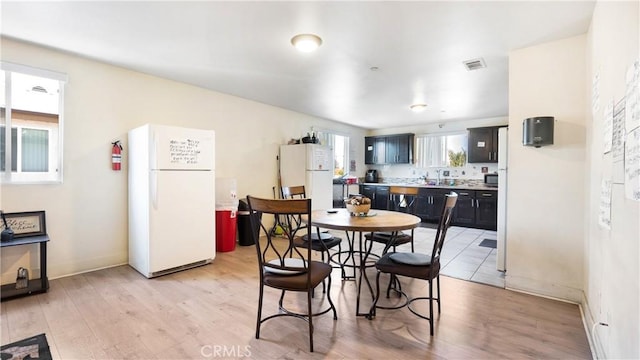 dining area with light wood-type flooring and baseboards
