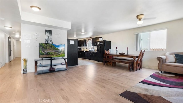 living room featuring light wood-style flooring and a ceiling fan