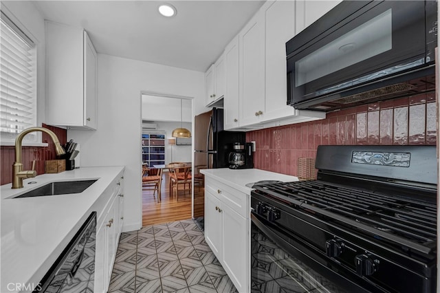kitchen featuring black appliances, a sink, white cabinets, light countertops, and recessed lighting