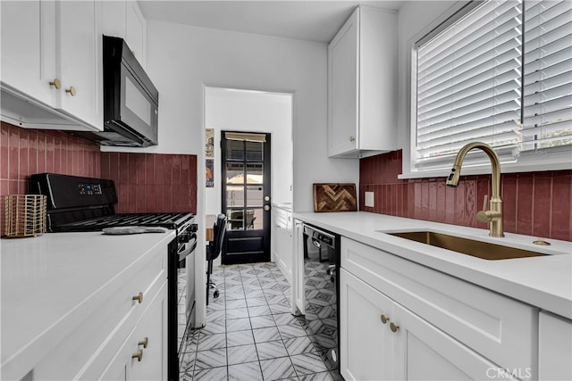 kitchen featuring black appliances, a sink, light countertops, and white cabinetry