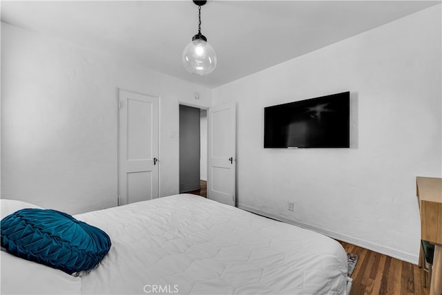 bedroom with baseboards and wood finished floors