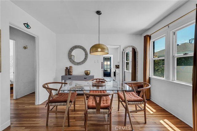 dining space with wood finished floors and baseboards