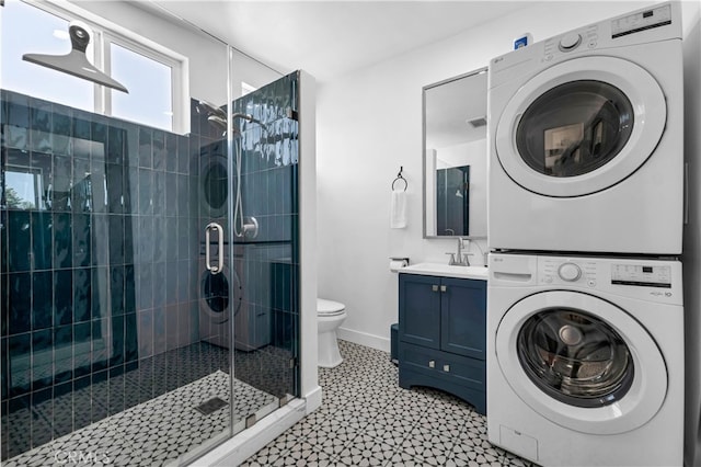 full bathroom featuring stacked washer and clothes dryer, a shower stall, tile patterned floors, and toilet