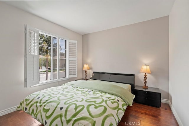 bedroom with hardwood / wood-style flooring and baseboards