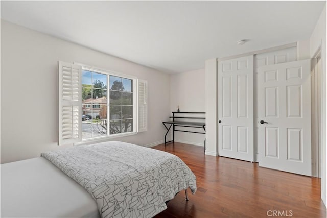 bedroom featuring wood finished floors, a closet, and baseboards