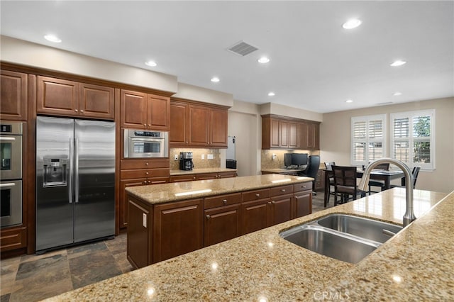 14538 Eagle River Rd, Eastvale, CA 92880 - kitchen featuring stainless steel appliances, a sink, light stone counters, decorative backsplash, and recessed lighting