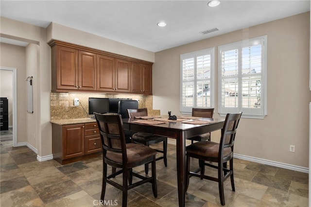 14538 Eagle River Rd, Eastvale, CA 92880 - dining room featuring baseboards, recessed lighting, built in desk, and dark stone finish floors