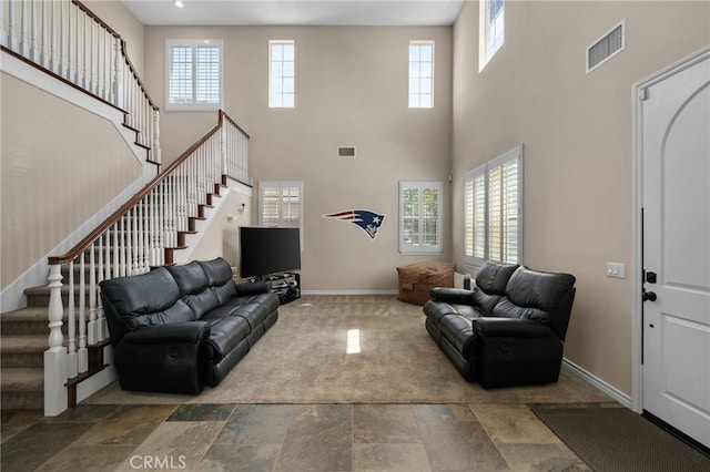 14538 Eagle River Rd, Eastvale, CA 92880 - living area with healthy amount of natural light, stairs, baseboards, a high ceiling, and stone finish floors