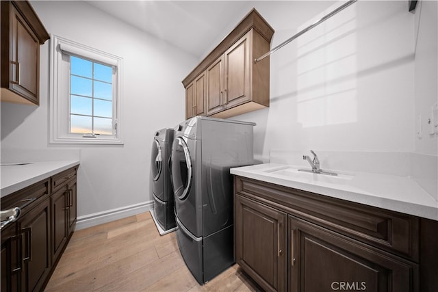 100 Headwaters, Irvine, CA 92602 - laundry area featuring cabinet space, separate washer and dryer, light wood-style floors, and baseboards