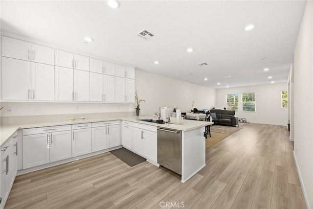 kitchen featuring stainless steel dishwasher, a peninsula, white cabinets, light wood-type flooring, and recessed lighting