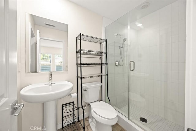 bathroom featuring a shower stall and toilet