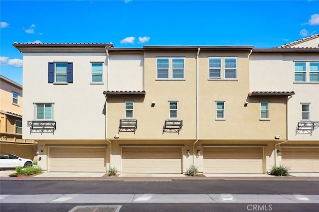 view of front facade with stucco siding and a garage