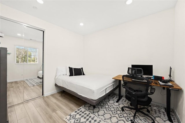 bedroom with light wood-type flooring, recessed lighting, baseboards, and an office area