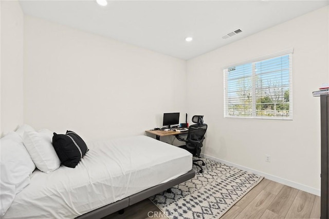 bedroom with baseboards, wood finished floors, and recessed lighting