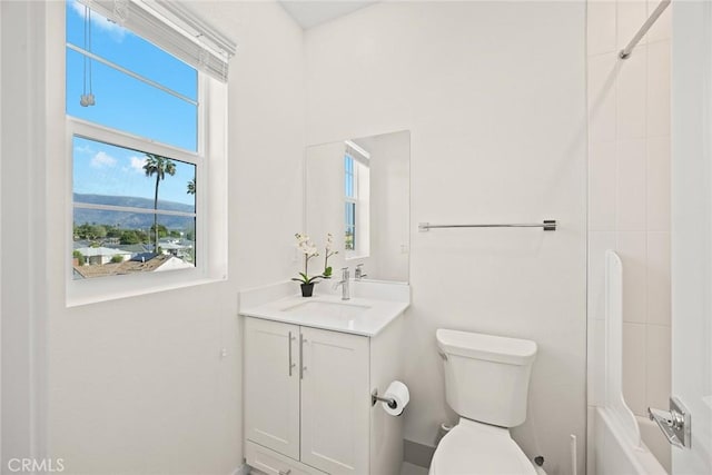 full bath featuring healthy amount of natural light, vanity, and toilet