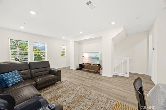 living room with light wood-type flooring, baseboards, and recessed lighting