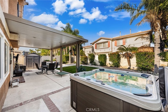 7189 Myrtle Pl, Fontana, CA 92336 - view of patio / terrace featuring a hot tub, a storage unit, a fenced backyard, an outdoor structure, and outdoor dining space