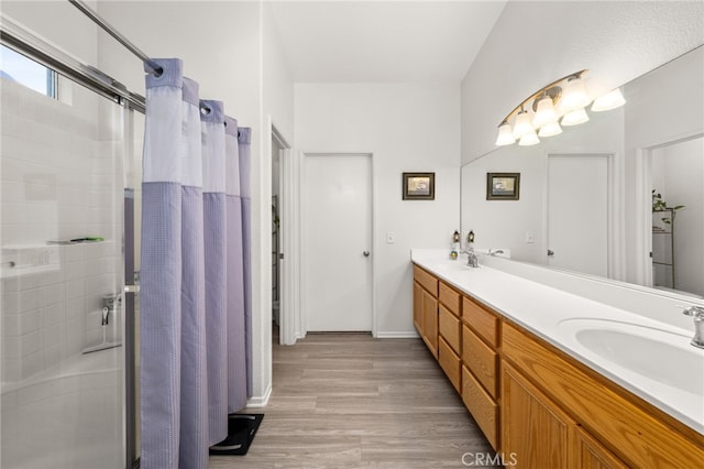7189 Myrtle Pl, Fontana, CA 92336 - bathroom with a stall shower, double vanity, wood finished floors, and baseboards