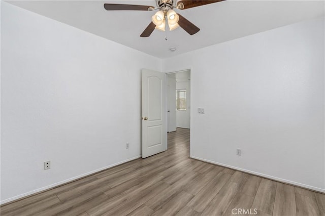 empty room featuring wood finished floors, ceiling fan, and baseboards