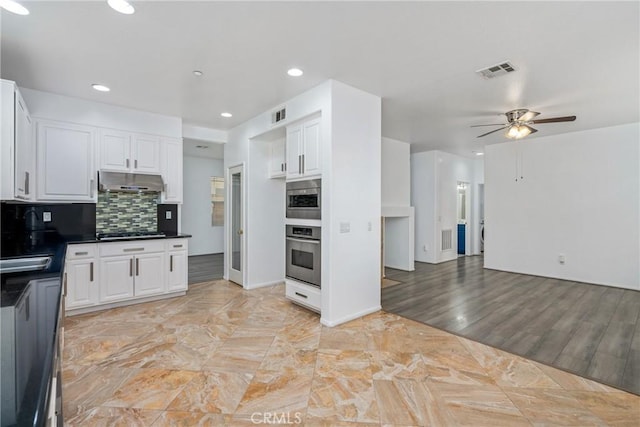 kitchen with stainless steel oven, under cabinet range hood, gas cooktop, white cabinets, and recessed lighting