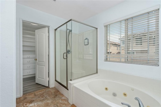 bathroom with a shower stall and a jetted tub