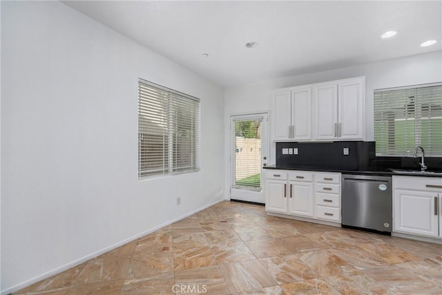 kitchen with dishwasher, a sink, white cabinets, and dark countertops