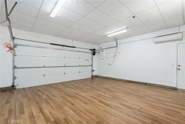 garage featuring an AC wall unit and baseboards