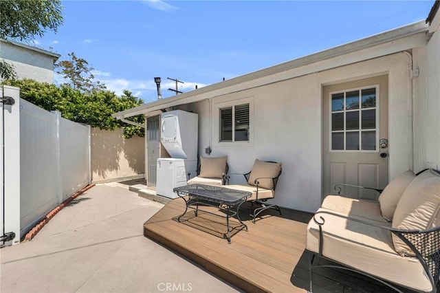 view of patio featuring fence, outdoor lounge area, and a wooden deck