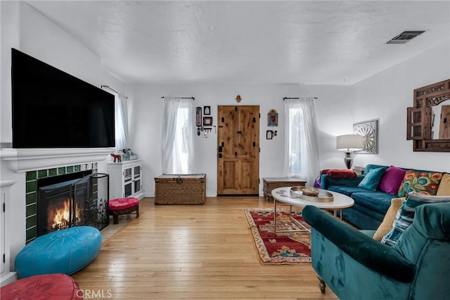 living area with hardwood / wood-style flooring and a fireplace