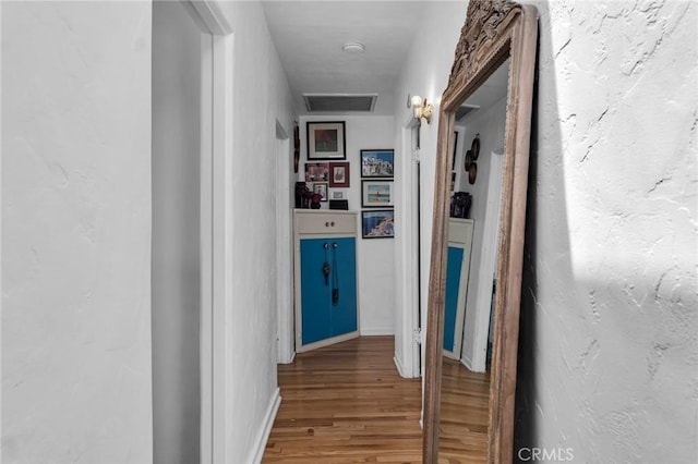 hallway featuring wood finished floors and baseboards