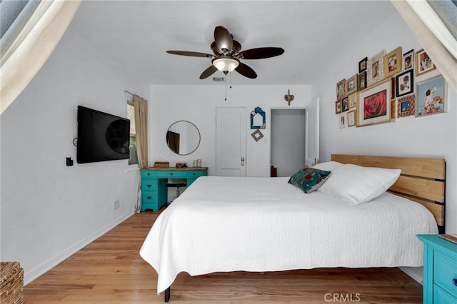 bedroom featuring light wood-type flooring, a ceiling fan, and baseboards
