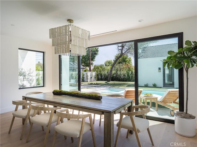 dining area featuring healthy amount of natural light, wood finished floors, and baseboards