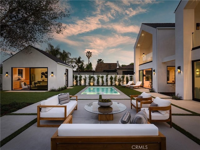 view of pool with an outdoor living space, a patio, and an outbuilding
