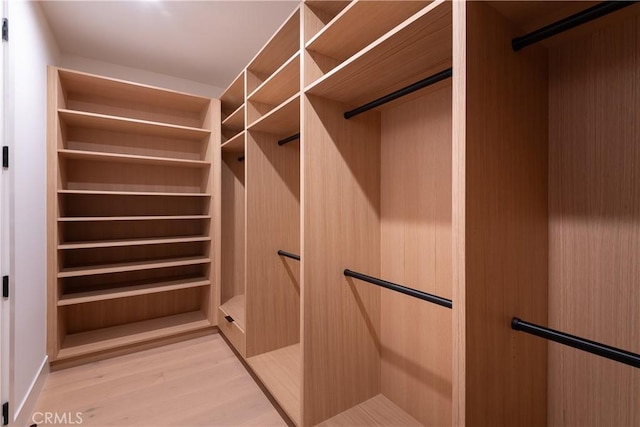 walk in closet with light wood-style floors