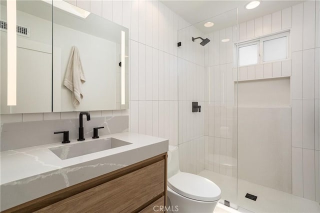 bathroom featuring a tile shower, toilet, vanity, and recessed lighting
