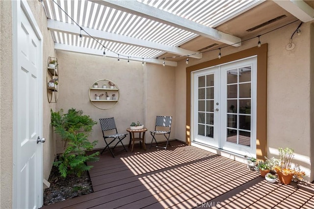 wooden terrace featuring french doors and a pergola