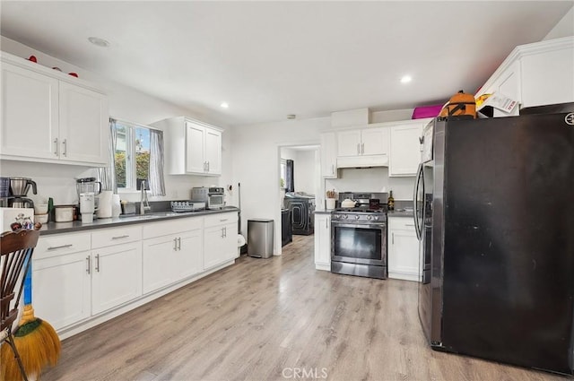 kitchen with freestanding refrigerator, stainless steel range with gas cooktop, light wood-style flooring, a sink, and white cabinets