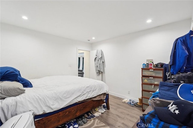 bedroom featuring wood finished floors, recessed lighting, and baseboards