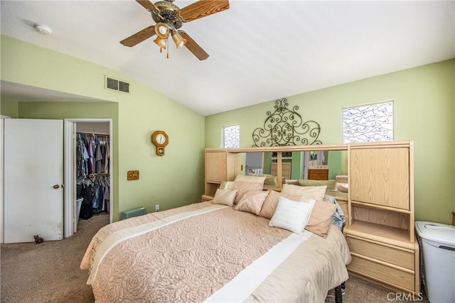 carpeted bedroom with vaulted ceiling, a spacious closet, ceiling fan, and a closet