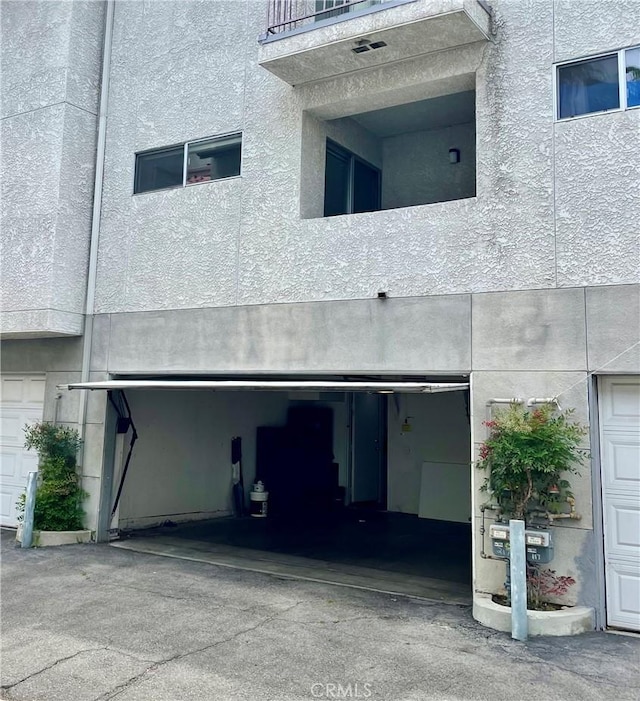 rear view of property featuring stucco siding and a garage