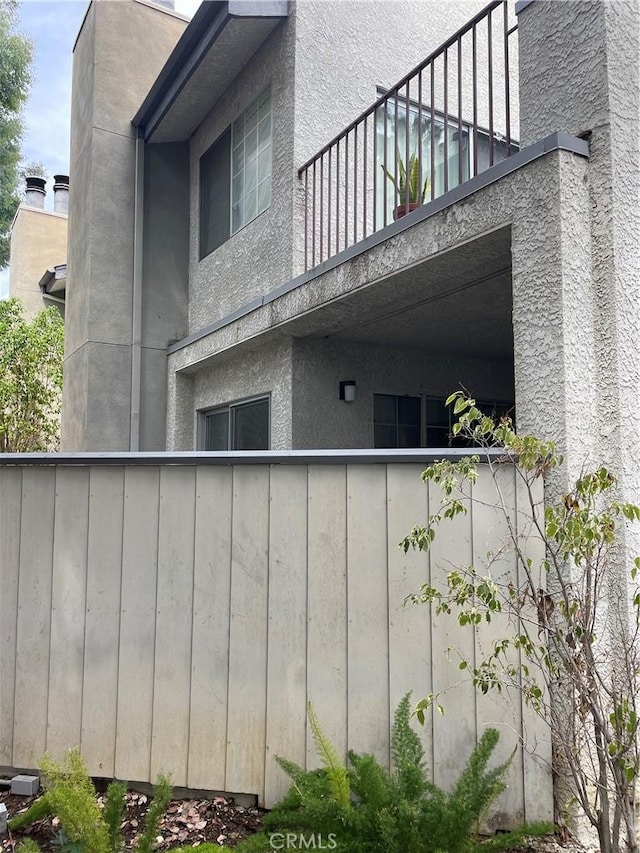 view of property exterior with a balcony and stucco siding