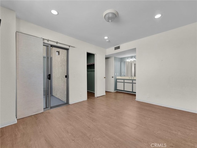 20155 Keswick St Unit 117, Winnetka, CA 91306 - unfurnished living room with wood finished floors, baseboards, recessed lighting, and a sink