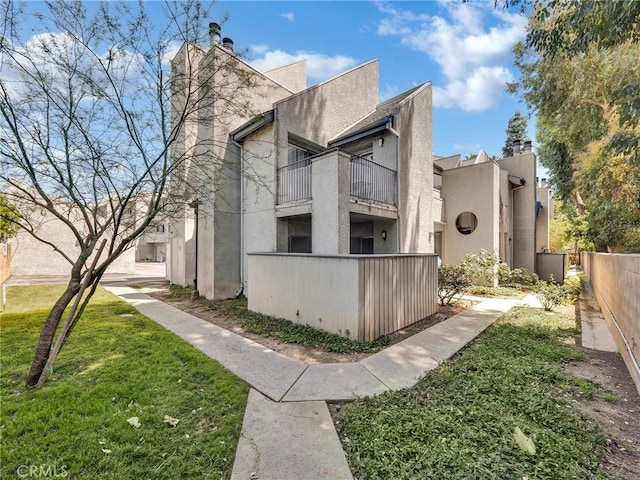20155 Keswick St Unit 117, Winnetka, CA 91306 - view of home's exterior with a balcony, stucco siding, and a chimney