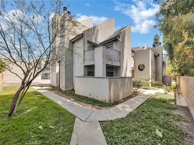 20155 Keswick St Unit 117, Winnetka, CA 91306 - view of property exterior featuring a balcony, stucco siding, and a chimney