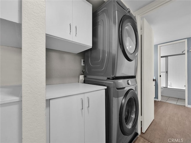 20155 Keswick St Unit 117, Winnetka, CA 91306 - washroom featuring cabinet space, stacked washer and clothes dryer, and wood finished floors